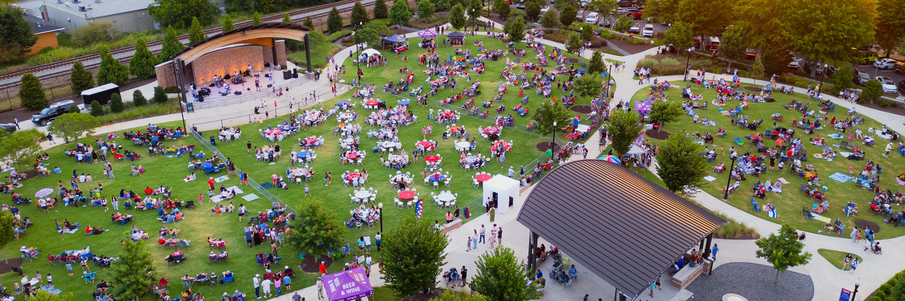 Jug Tavern Park aerial view, packed during Celebrate Winder, as the band plays on stage and the sun sets