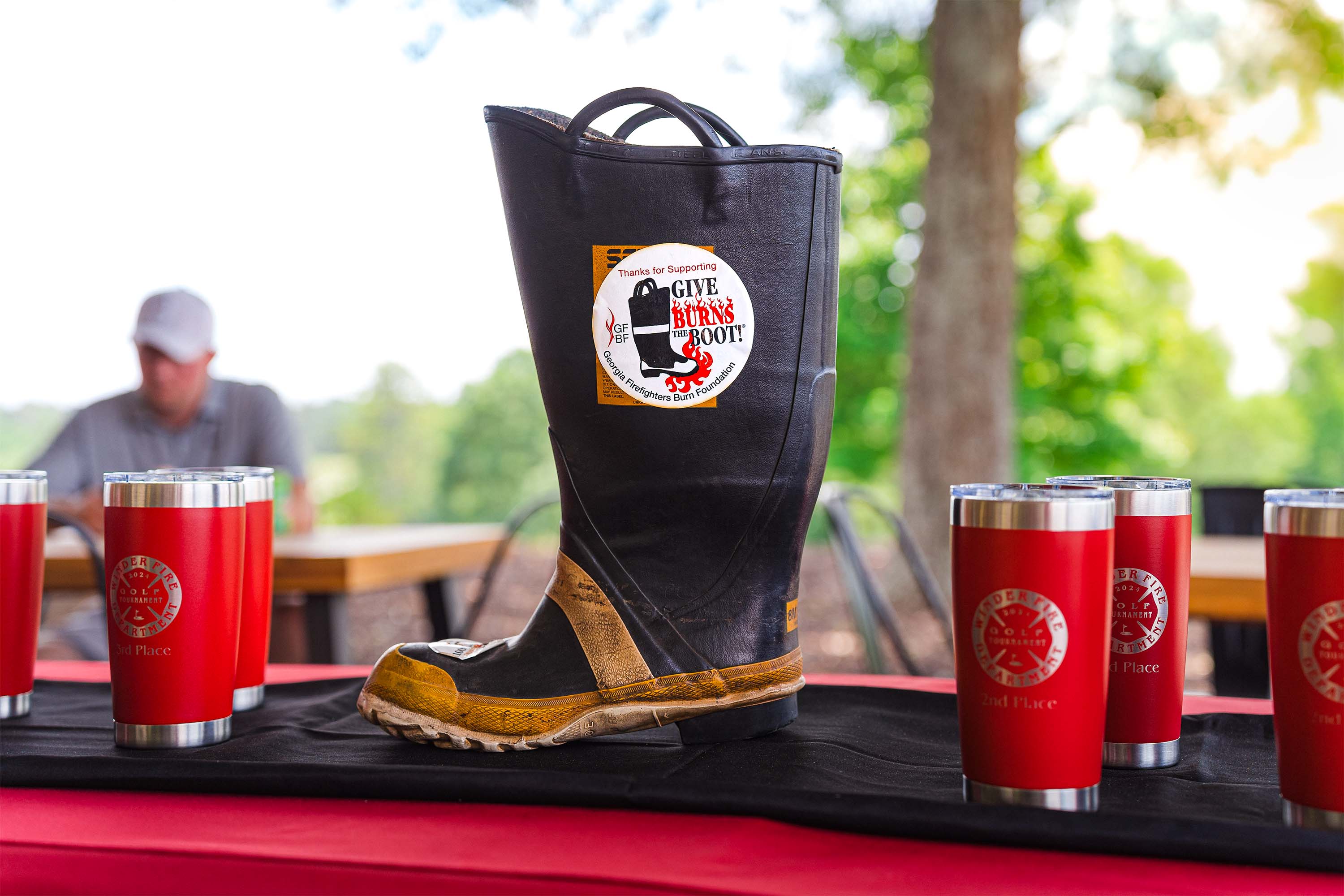 A firefighter's boot on a table, with a sticker that reads 